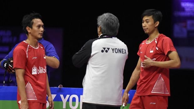 Indonesia's Mohammad Ahsan and Rian Agung Saputro (R) touch to their coach as they play against China's Liu Cheng and Zhang Nan during their men's doubles final match during the 2017 BWF World Championships of badminton at Emirates Arena in Glasgow on August 27, 2017. (Photo by ANDY BUCHANAN / AFP)