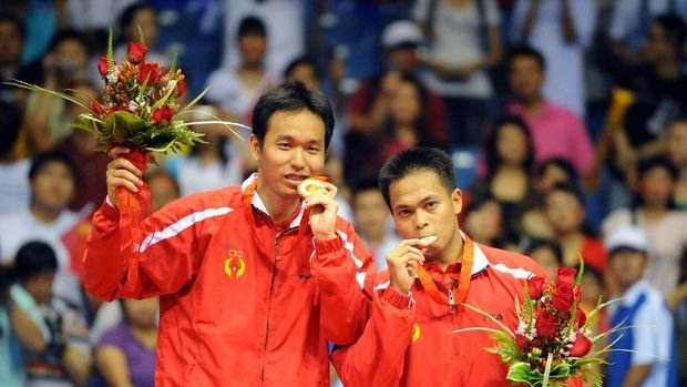 Markis Kido (R) and Hendra Setiawan of Indonesia celebrate with their gold medals in the men's badminton doubles event of the 2008 Beijing Olympic Games in Beijing on August 16, 2008. Kido and Setiawan beat Cai Yun and Fu Haifeng of China 12-21, 21-11, 21-16.       AFP PHOTO/GOH CHAI HIN (Photo by GOH CHAI HIN / AFP)